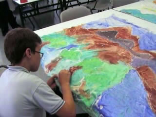 Nios pintando un mural sobre mesa